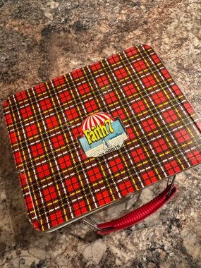 Vintage Ohio Art tin lunchbox with red plaid design.